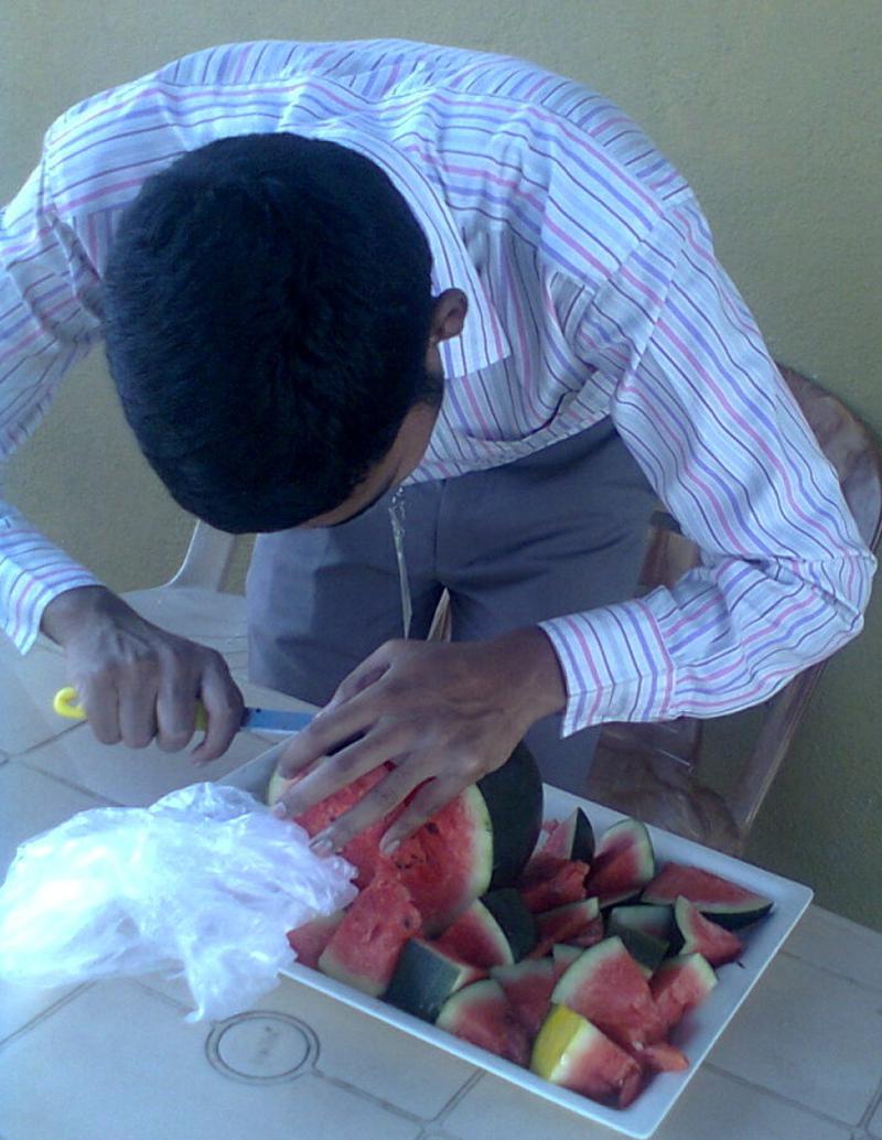 visually impaired adult cutting a watermelon